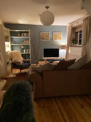 a living room with a couch and a television at Archers Cottage in Leominster