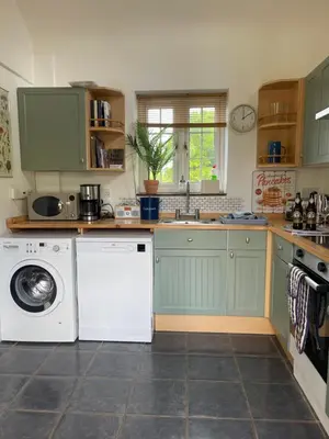 a kitchen with a washing machine and a washer at Archers Cottage in Leominster
