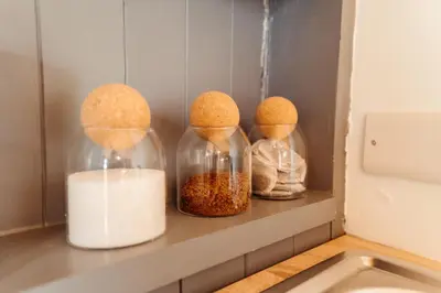 a shelf with three glass jars with food in them at Cefn Crib Cabins in Machynlleth