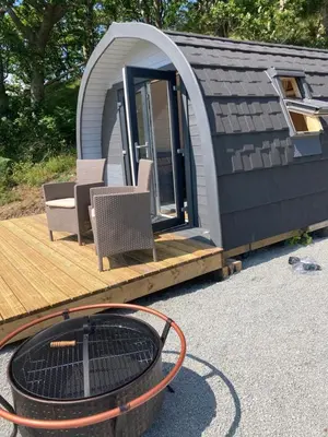 a tiny house with a deck and a fire pit at Cefn Crib Cabins in Machynlleth