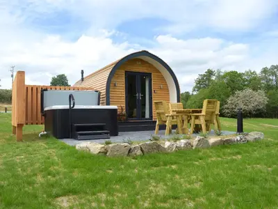 a small cabin with a grill and a table and chairs at Efyrnwy Pod Vip in Llanfyllin