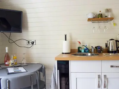 a kitchen with a sink and a tv on a counter at Efyrnwy Pod Vip in Llanfyllin