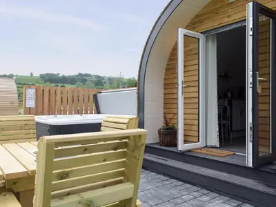 a patio with a table and bench on a house at Efyrnwy Pod Vip in Llanfyllin