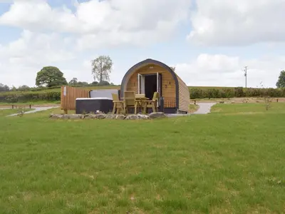 a small wooden cabin in a field of grass at Efyrnwy Pod Vip in Llanfyllin