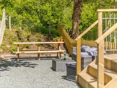 a picnic table and bench next to a tree at Barn Owls Rest in Clyro