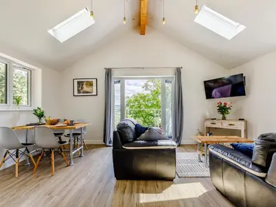 a living room with two couches and a table at Barn Owls Rest in Clyro