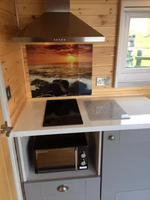 a kitchen with a counter top with a microwave at Cwt y Bugail in Barmouth