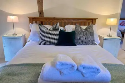 a bed with two blue towels on top of it at Upper Heath Farm - Stable Cottage Ludlow in Craven Arms