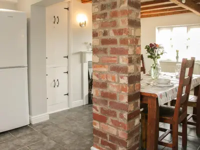 a kitchen and dining room with a brick wall at 1 Royal Oak Cottages in Shrewsbury