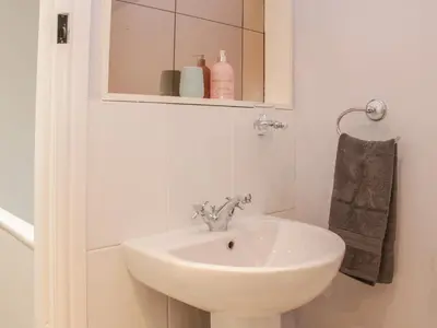 a white bathroom with a sink and a mirror at 1 Royal Oak Cottages in Shrewsbury