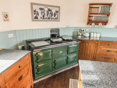 a kitchen with a green stove and a counter at Top Farm House in Oswestry