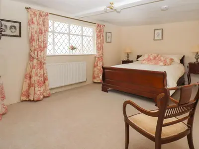 a bedroom with a bed and a chair and a window at Top Farm House in Oswestry