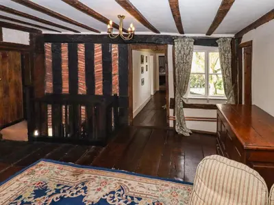 a living room with wooden floors and a ceiling at Top Farm House in Oswestry