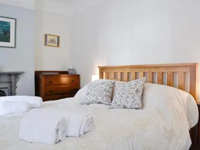 a bed with white sheets and pillows on it at The Mill House, The Square in Talgarth
