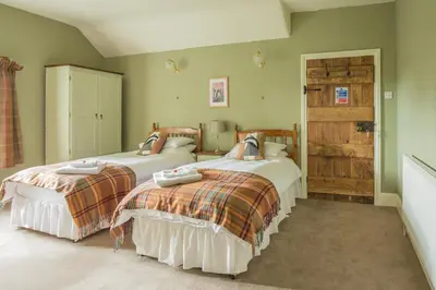 two beds in a bedroom with green walls at Lower House B&B and Cottages, Adforton in Leintwardine