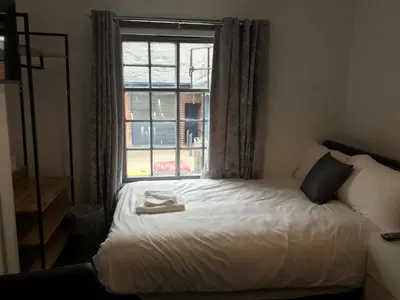 a bed in a room with a window at Ty'r Bont Studios in Newtown