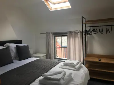 a bedroom with a bed with towels on it at Ty'r Bont Studios in Newtown