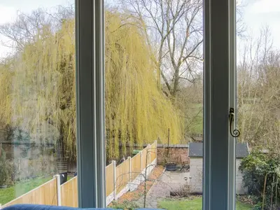 a window with a view of a fence and a tree at Willow View in Shrewsbury