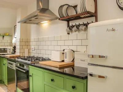a kitchen with green cabinets and a stove at Willow View in Shrewsbury