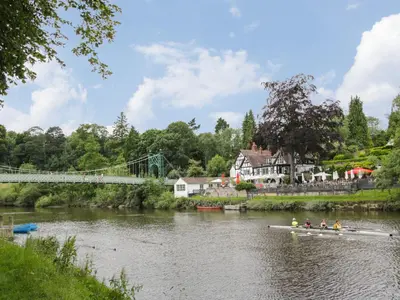 a group of people rowing a boat down a river at Willow View in Shrewsbury