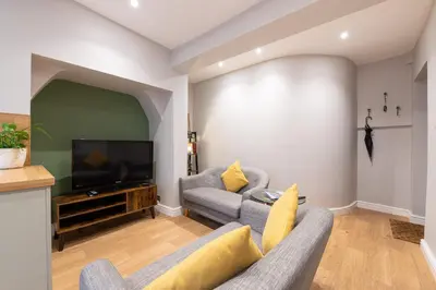 a living room with two couches and a flat screen tv at Coach House, Shrewsbury Town in Shrewsbury