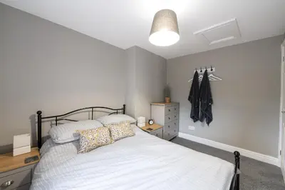 a bedroom with a bed and a dresser in it at Coach House, Shrewsbury Town in Shrewsbury
