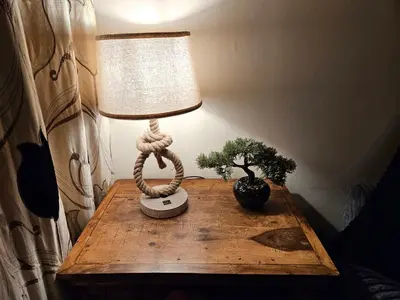 a lamp on a wooden table with a plant on it at Ridge And Tides in Fairbourne