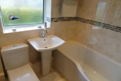 a bathroom with a sink and a toilet and a tub at Ridge And Tides in Fairbourne