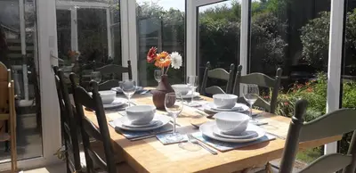 a wooden table with glasses and plates on it at Ridge And Tides in Fairbourne