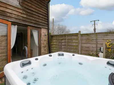 a hot tub in the backyard of a house at Beekeeper's Cottage in Leominster