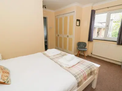 a bedroom with a large white bed and a chair at Tynewydd Fields in Lampeter