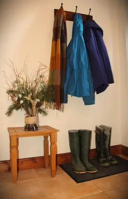 a room with a table with a plant and boots at The Calf Cotts in Pembridge