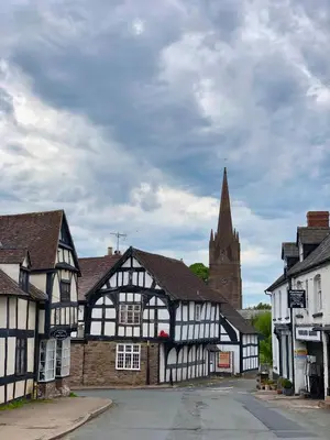 a town with black and white buildings and a church at The Calf Cotts in Pembridge
