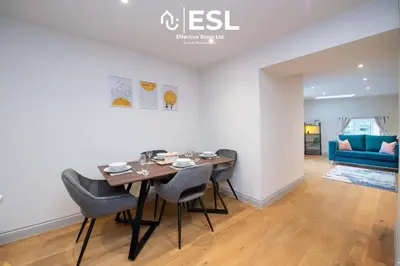 a dining room with a table and chairs and a blue couch at High Quality 2 Bedroom Church Apartment 5 Mins to Town Centre - Free Parking in Shrewsbury
