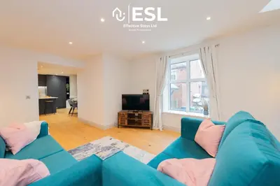 a living room with a blue couch and a television at High Quality 2 Bedroom Church Apartment 5 Mins to Town Centre - Free Parking in Shrewsbury