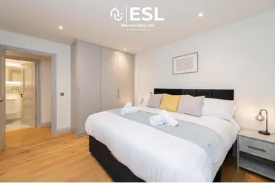 a bedroom with a large bed with white sheets at High Quality 2 Bedroom Church Apartment 5 Mins to Town Centre - Free Parking in Shrewsbury