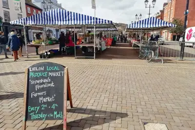 a market with a sign in the middle of a street at Cosy, elegant apartment in heart of Ludlow Town in Ludlow