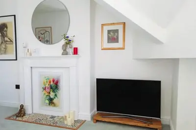 a living room with a tv and a fireplace at Cosy, elegant apartment in heart of Ludlow Town in Ludlow