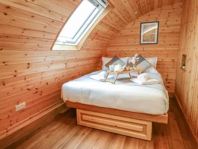 a bedroom with a bed in a log cabin at Buttercup in Rhayader