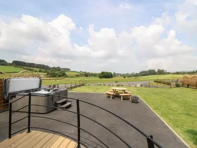 a deck with a grill and a picnic table at Buttercup in Rhayader