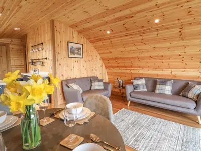 a living room with a table with yellow flowers on it at Bluebell in Rhayader