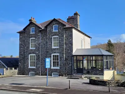 a large brick building with a gazebo in front of it at Llys Bach Apartment at Llys Aeron in Aberaeron