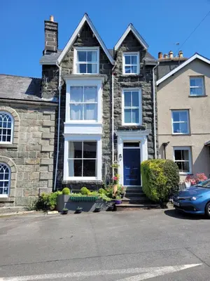 a large stone house with a blue door at Afallon Townhouse in Dolgellau