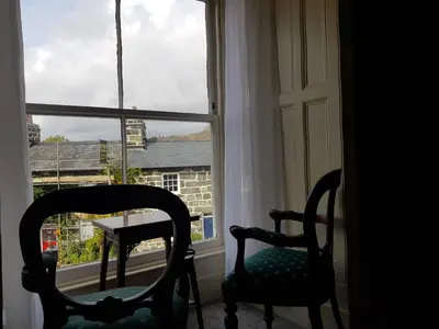 two chairs and a table in front of a window at Afallon Townhouse in Dolgellau