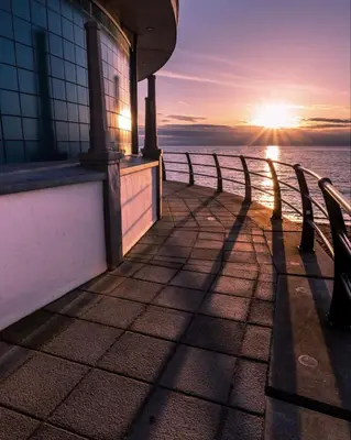 a view of the ocean from a pier at sunset at No 31 Promenade APARTMENT by the sea in Aberystwyth