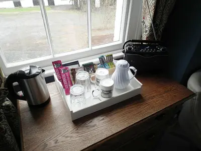 a table with a tray with cups and glasses on it at Upper Buckton B&B in Leintwardine