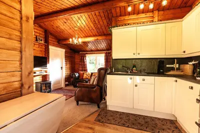 a kitchen with white cabinets in a log cabin at Stunning Log Cabin with Garden in Snowdonia - Hosted by Seren Short Stays in Trawsfynydd