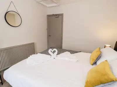 a white bed with two swans on top of it at Rose Suite in Barmouth