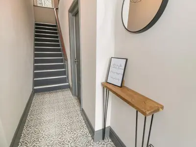 a hallway with a staircase and a mirror on the wall at Rose Suite in Barmouth