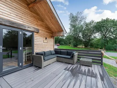 a patio with a couch on a wooden deck at Dwrgi - Uk32923 in Cwrt-newydd